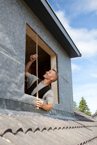 contractor measuring window opening in a new shed dormer